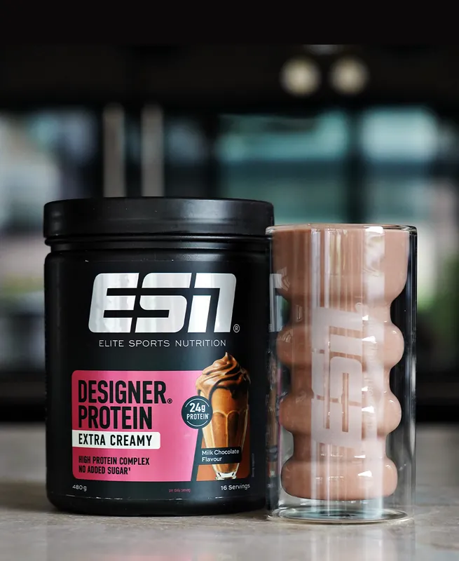 ESN Designer Protein Extra Creamy – Milk Chocolate, met een glas