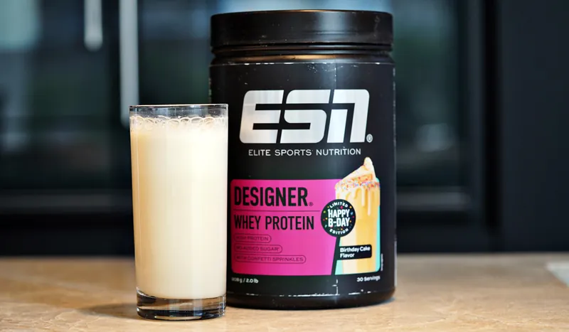 ESN Designer Whey Protein – Birthday Cake, met een glas