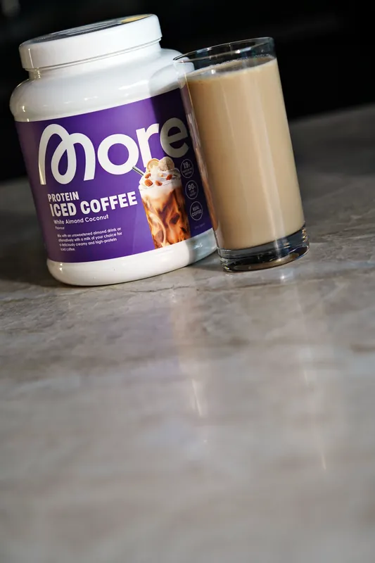 More Protein Iced Coffee – White Almond Coconut, met een glas